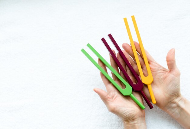 Tuning forks in hands of woman