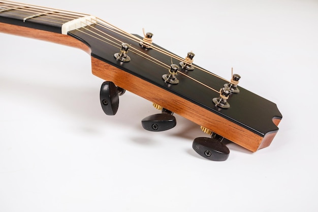 白い背景の上の6弦ギターの木製マシンヘッドのチューニングペグ
