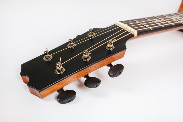 白い背景の上の6弦ギターの木製マシンヘッドのチューニングペグ