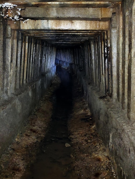 The tunnel of the underground sewage collector with ribbed walls going into perspective