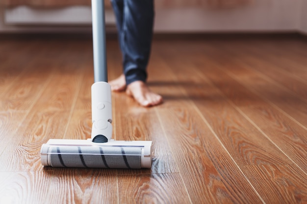 Turbo brush cordless vacuum cleaner closeup cleans the parquet\
in the house