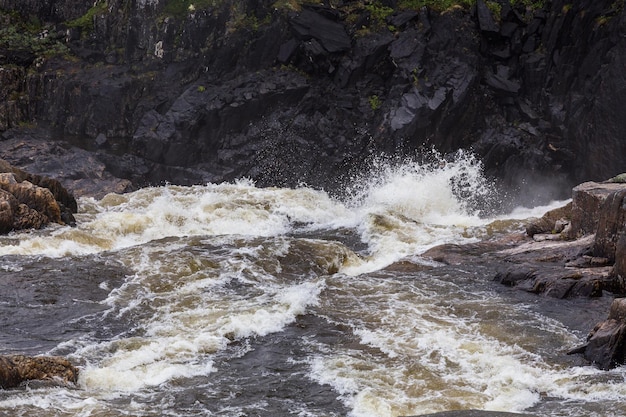 Turbulente waterstromen spatten tussen de rotsen