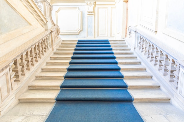 TURIN, ITALY - CIRCA JUNE 2021: The most beautiful Baroque staircase of Europe located in Madama Palace (Palazzo Madama). Interior with luxury marbles, windows and corridors.