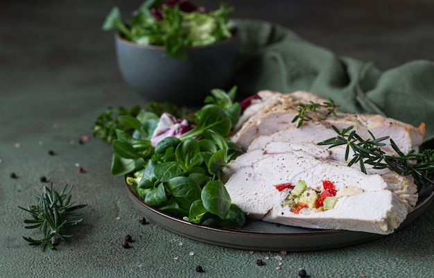 Turkey breast stuffed with vegetables and cheese served with green mix salad and aromatic herbs