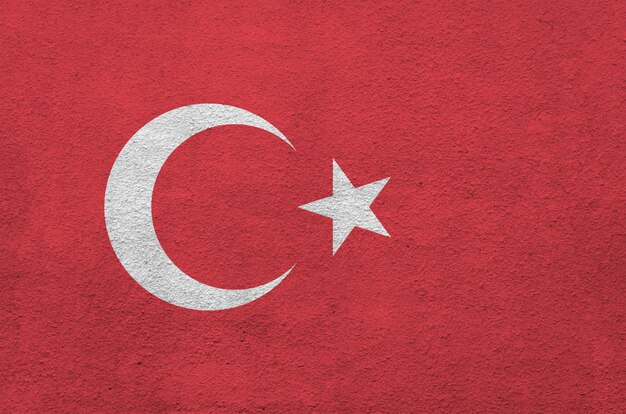 Photo turkey flag depicted in bright paint colors on old relief plastering wall.