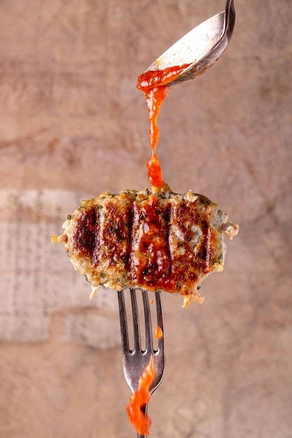 Turkey and spinach cutlet with vegetable sauce on a fork