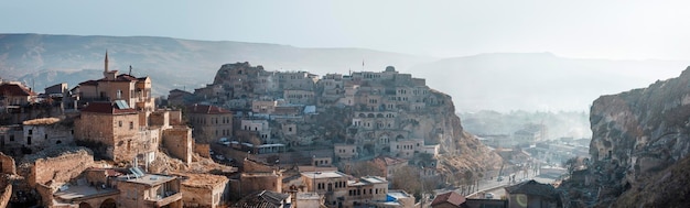 Turkije, Urgup - november 2020: Panarama van de stad in de ochtend vanaf de berg. Uitzicht op de oude stenen herenhuizen in de kloof