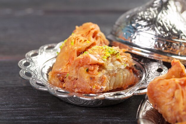 Turkish arabic dessert baklava with honey and nuts on a silver plate