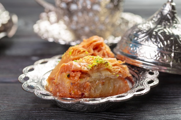 Turkish arabic dessert baklava with honey and nuts on a silver plate