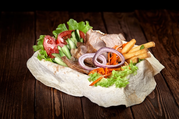 Turkish and Arabic Traditional mix kebab plate. Kebab beef on lavash bread with sauce and vegetables.