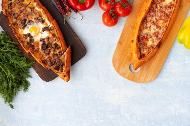 Turkish baked pide bread on light blue wooden surface