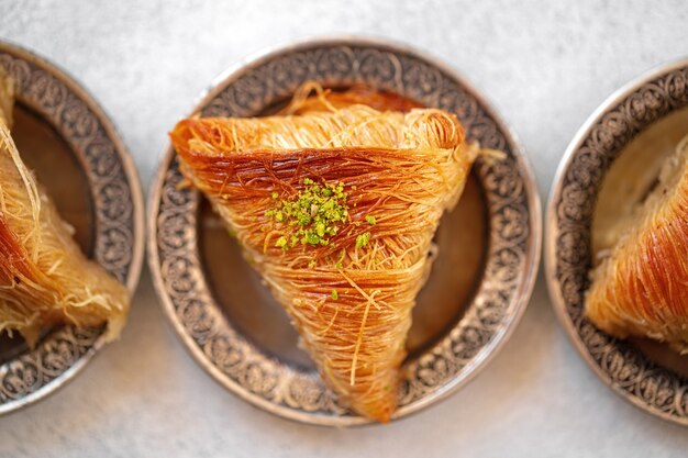 Turkish baklava on oriental metal plate on white table