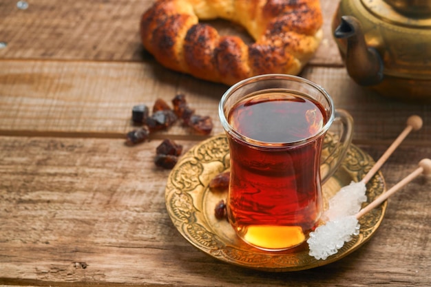 Turkish black tea Glass cup of turkish black tea and crispy Turkish traditional bagel on old rustick background Breakfast pastry concept Traditional turkish brewed hot drink