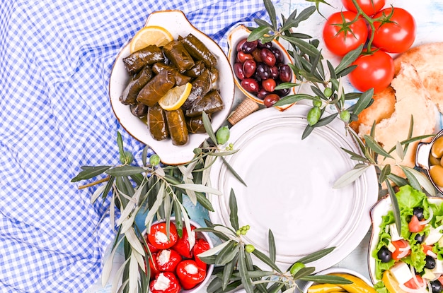 Turkish cabbage rolls and various snacks of national cuisine. Rice in grape leaves and olives. Food for a traditional oriental lunch. Free space for text, empty plate