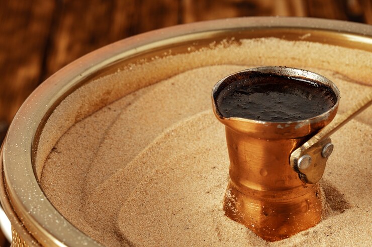 Photo turkish coffee in cezve on the sand