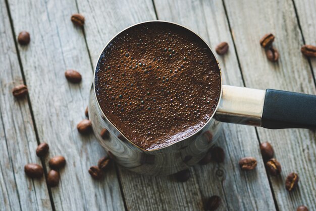 Turkish coffee in cezve on wooden table