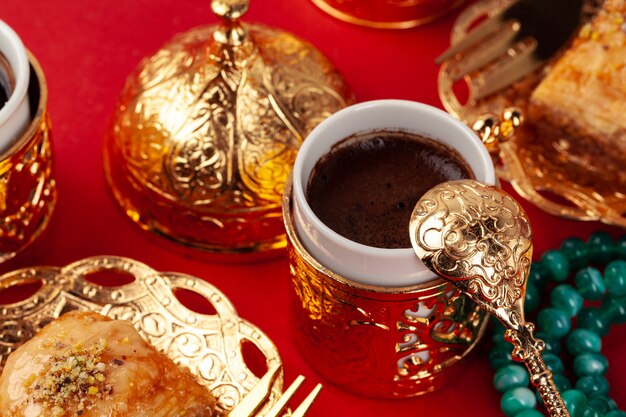 Turkish coffee in a golden oriental cup on red background