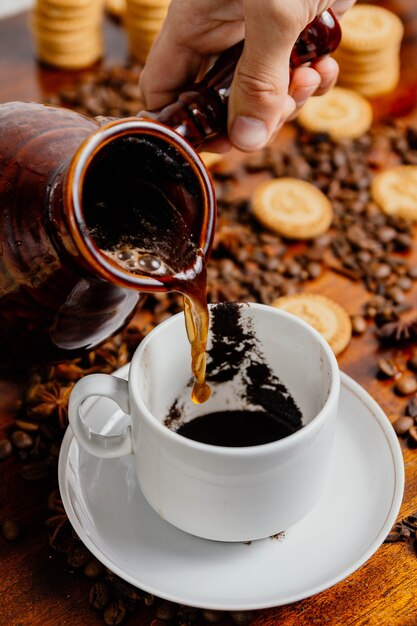 Caffè turco che versa il caffè nella tazza