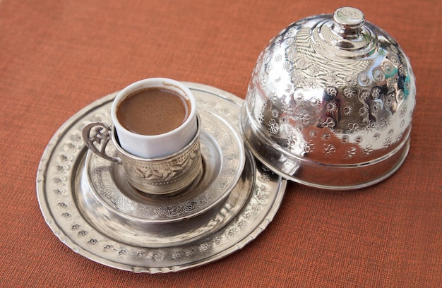 Turkish coffee served in a traditional Turkish metal dish cap