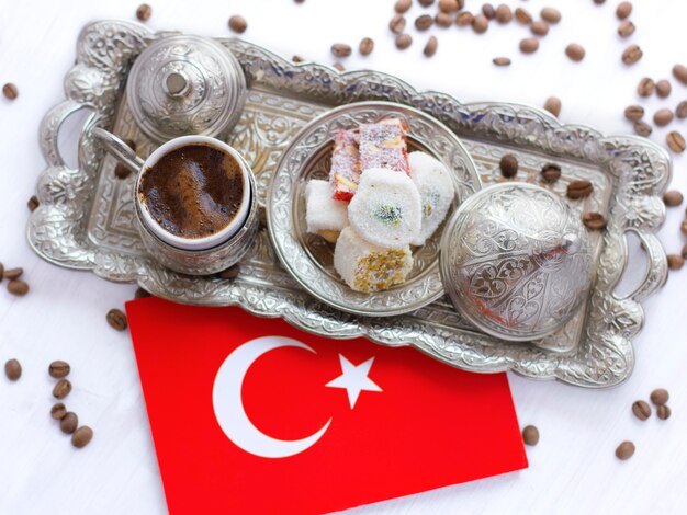 Turkish coffee on a traditional silver tray with Turkish sweets and the red flag of Turkey