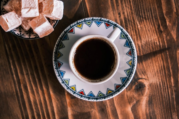 Photo turkish coffee with traditional porcelain cup on a wooden table coffee presentation with turkish delight