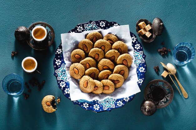 Photo turkish cookies with almonds and coffee on the table in