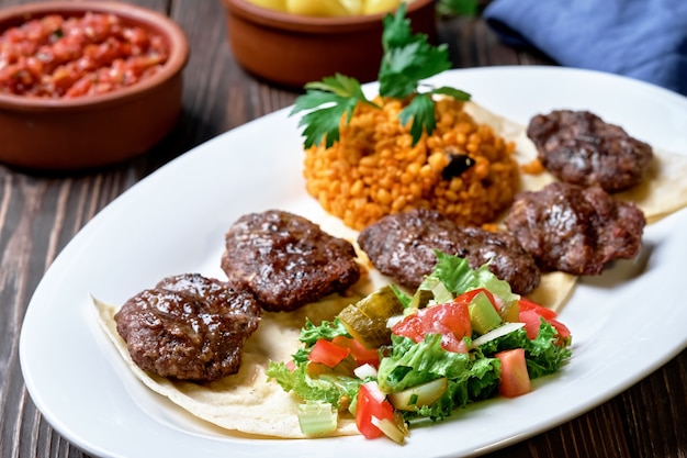 Turkish cutlets made from lamb and beef meat and spices with salad and rice