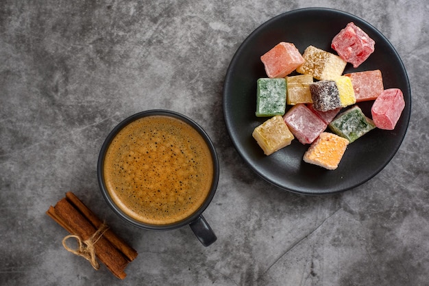 Turkish delight and cup of coffee on grey background Top view