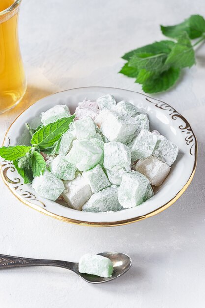 Turkish delight lokum on a plate with a glass of tea