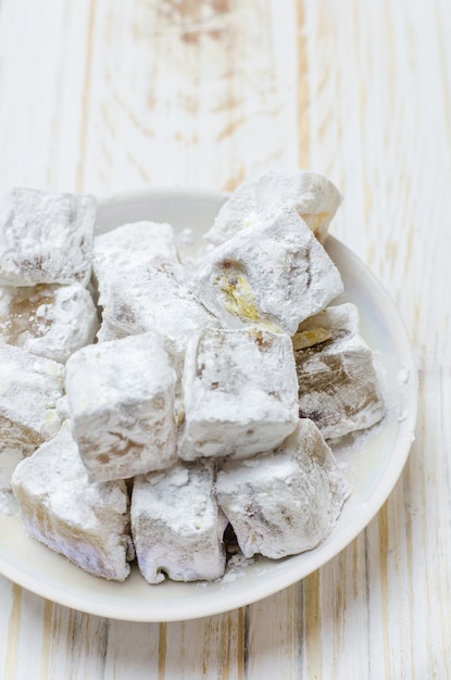 Turkish delight with pistachios on wooden table