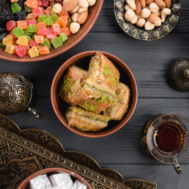 Foto baklava turca del dessert con i frutti secchi e dadi sullo scrittorio di legno