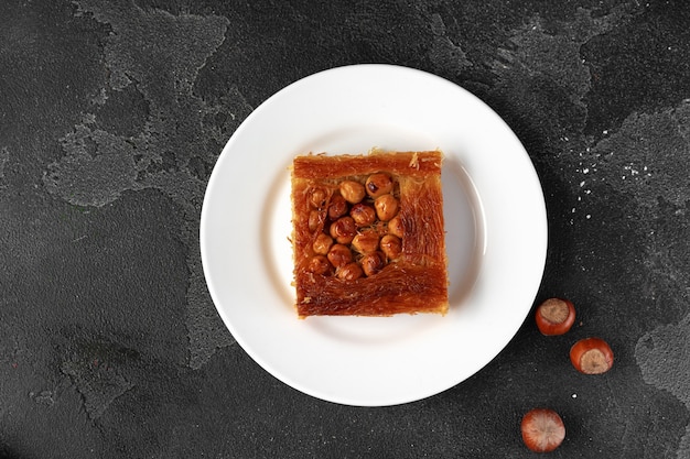 Turkish dessert baklava with nuts on black background