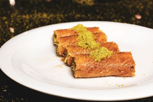 Photo turkish dessert kunefe kunafa kadayif with pistachio powder and cheese hot eaten a sweet