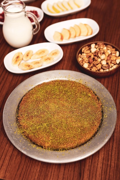 Turkish dessert kunefe kunafa kadayif with pistachio powder and cheese hot eaten a sweet