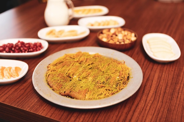 Turkish dessert kunefe kunafa kadayif with pistachio powder and cheese hot eaten a sweet