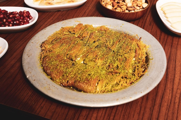 Foto dessert turco kunefe kunafa kadayif con polvere di pistacchio e formaggio caldo mangiato un dolce