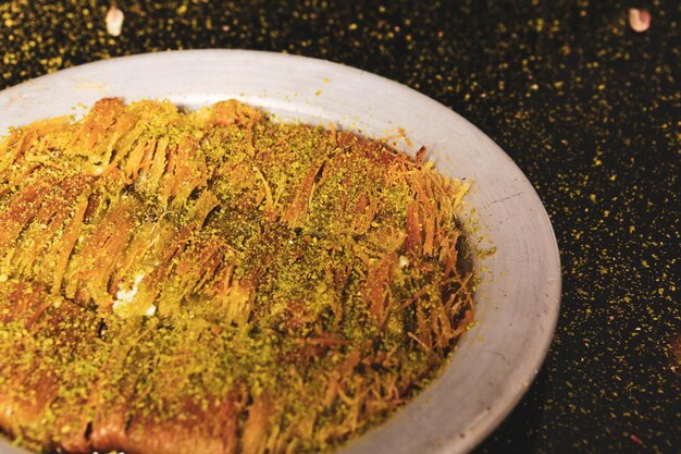 Turkish dessert kunefe kunafa kadayif with pistachio powder and cheese hot eaten a sweet