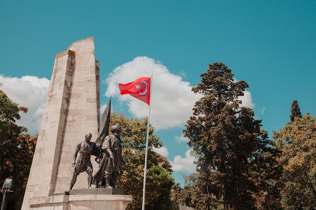 화창한 날 공원의 배경에 푸른 하늘이 있는 터키 국기 터키 애국심 개념