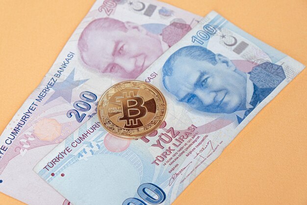 Банкноты турецкой лиры и монета биткойн
