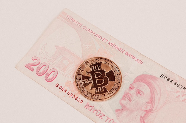 Банкноты турецкой лиры и монета биткойн