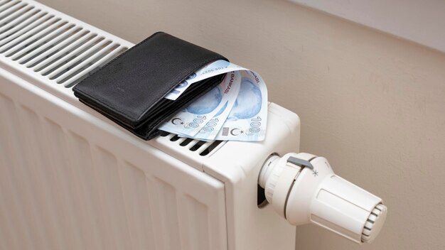 Turkish lira banknotes on heating radiator the concept of expensive heating costs