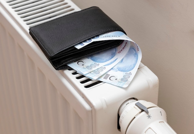 Turkish lira banknotes on heating radiator the concept of expensive heating costs