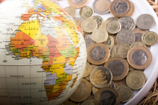 Turkish Lira coins by the side of a model globe