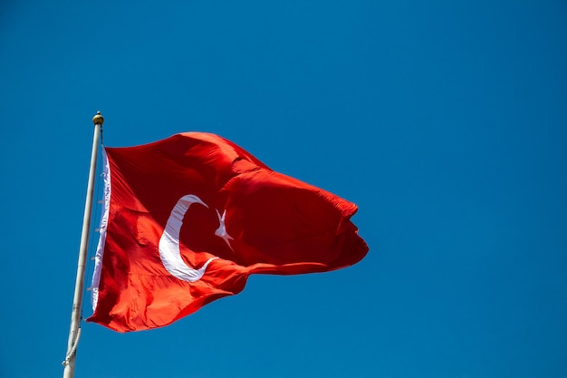 Turkish national flag with white star and moon in sky
