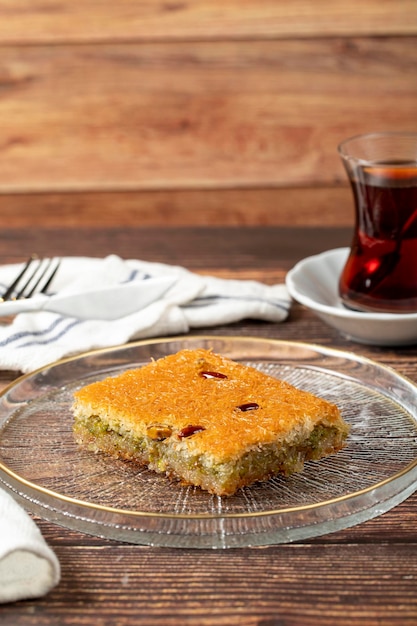 Turkish pistachio kadayif Turkish cuisine delicacies Kadayif dessert in a plate on a wooden background close up