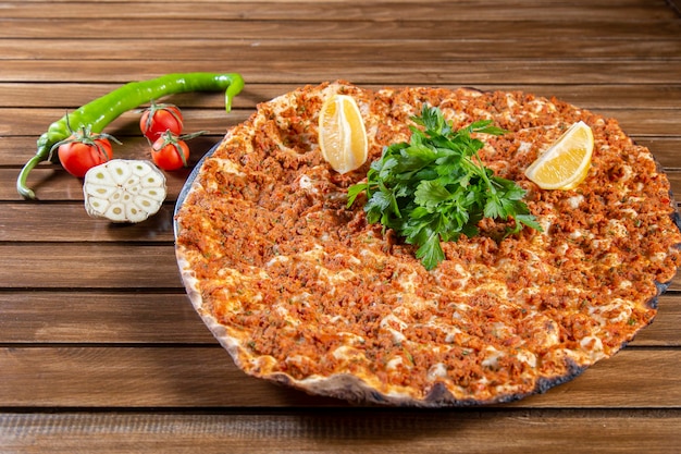 Фото Турецкая пицца, также известная как вид на лахмаджун с овощами на старинном деревянном столе