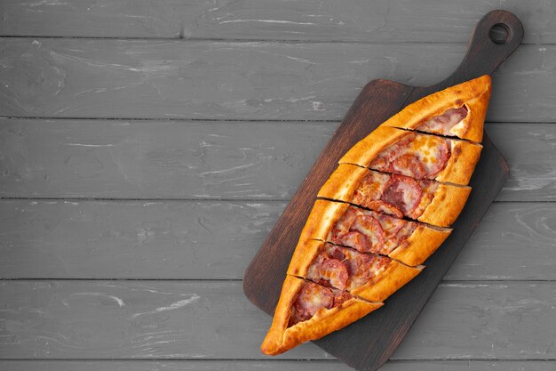 Turkish stuffed flatbread pide on gray wooden table