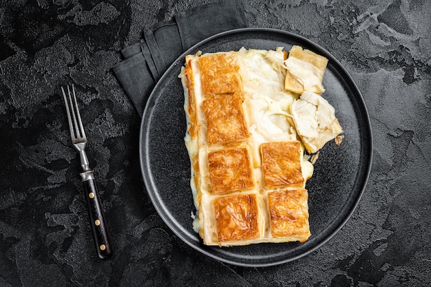 Photo turkish su boregi pie tabla borek or burek in plate black background top view