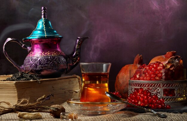 Turkish tea in the teapot and cup with tea near a vase