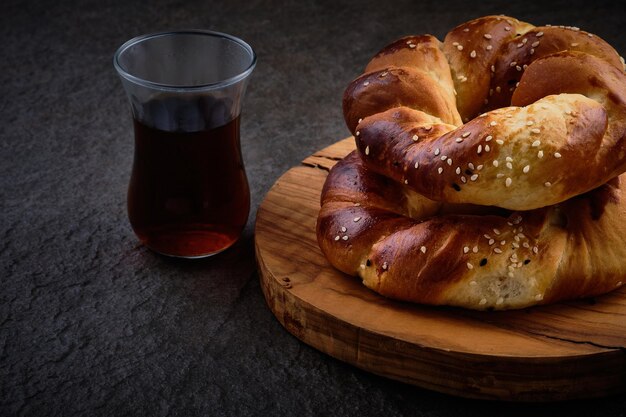 Photo turkish tea in traditional glass and traditional turkish pastry acma baked sesame encrusted bagels